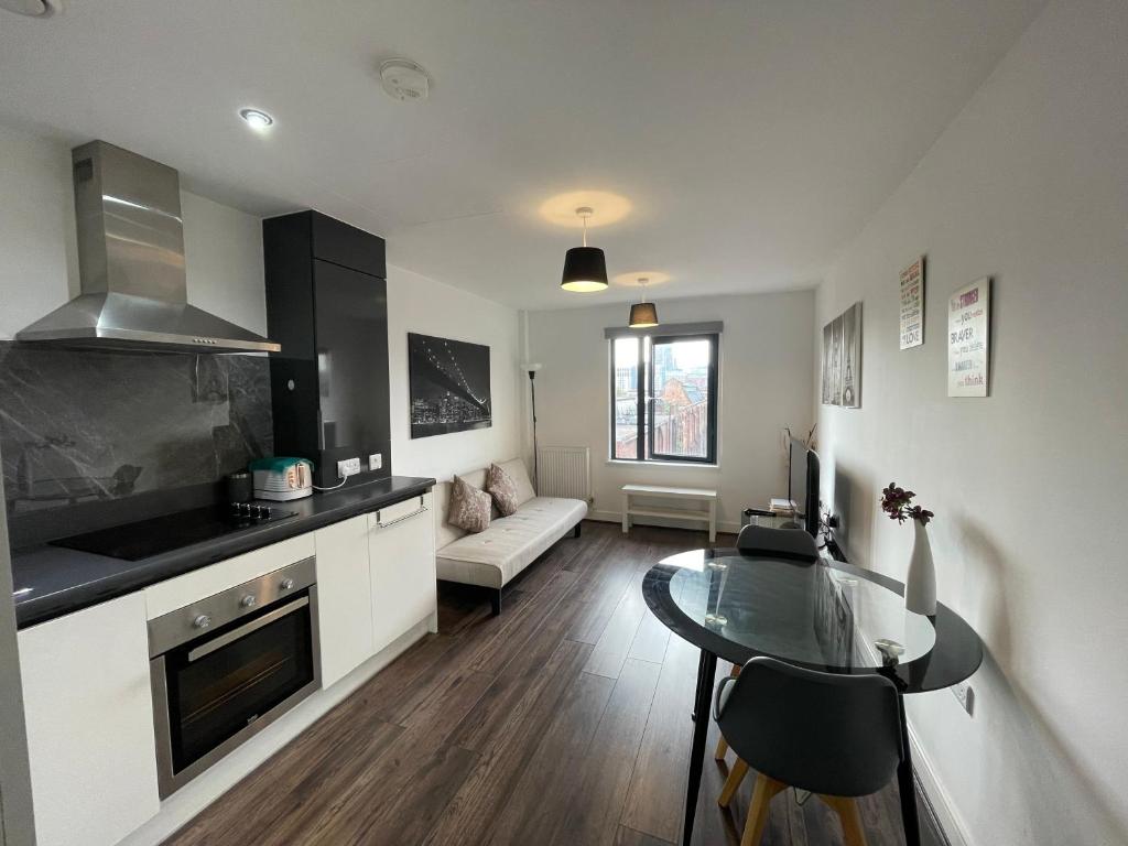 a kitchen and living room with a table and a couch at Modern Apartment near Bullring in Birmingham