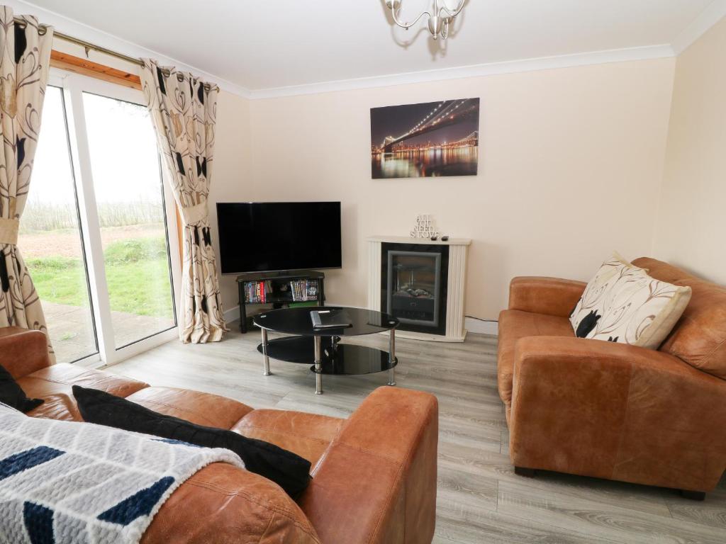 a living room with two couches and a tv at Hembry Meadows in Callington