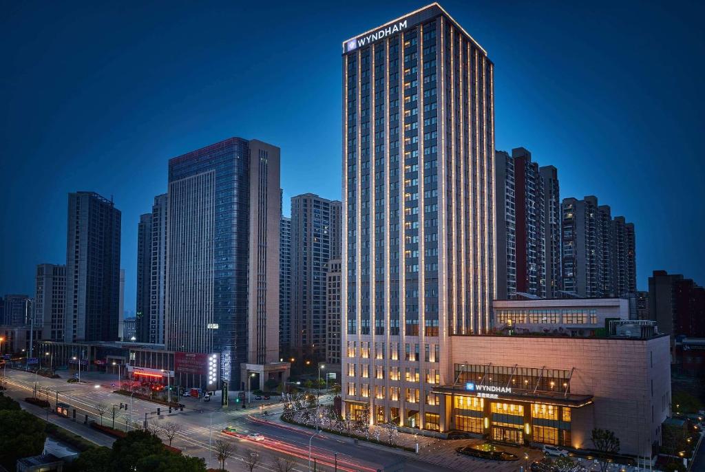 Jingzhou的住宿－荊州南國溫德姆酒店，夜晚在城市的高楼