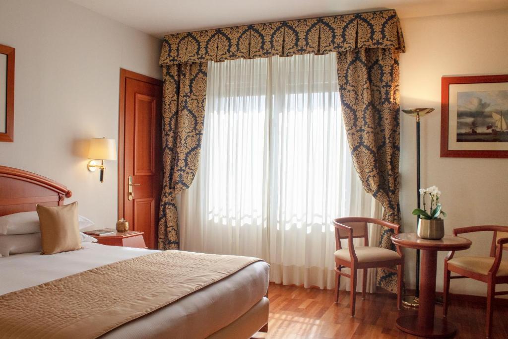 um quarto de hotel com uma cama e uma janela em Starhotels Vespucci em Campi Bisenzio