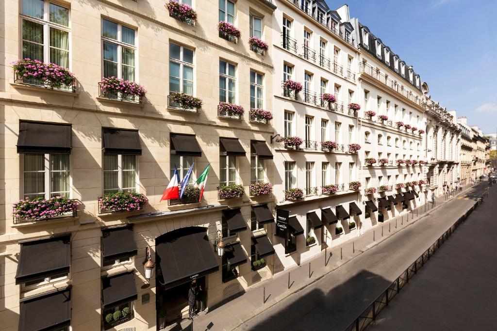 un bâtiment avec des boîtes de fleurs sur son côté dans l'établissement Castille Paris – Starhotels Collezione, à Paris