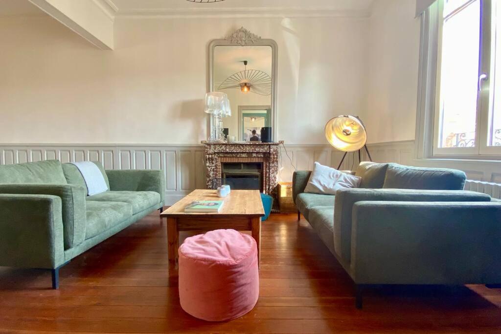 a living room with couches and a table and a mirror at La Villa Dorange, EXCEPTIONNELLE et SPACIEUSE in Sailly-Flibeaucourt