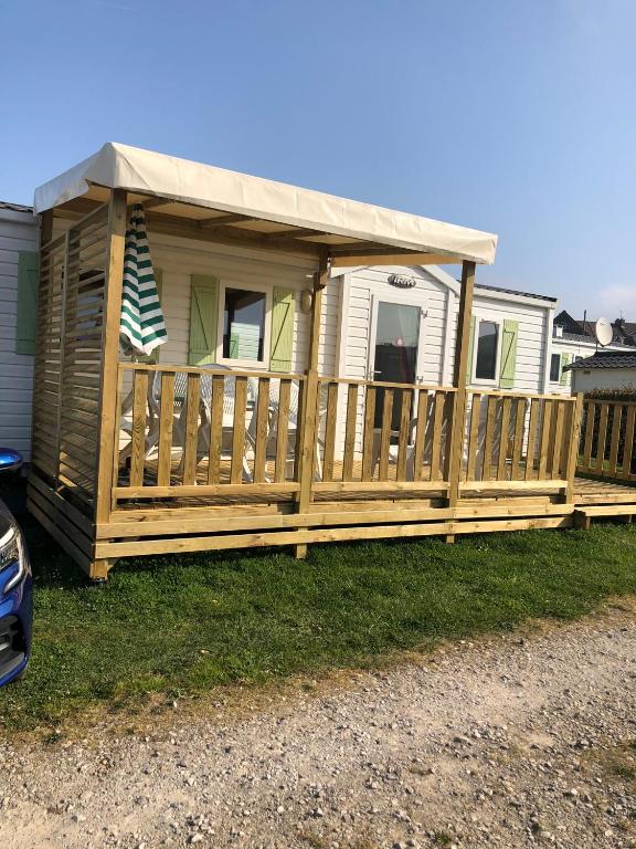 une terrasse en bois avec un toit sur une maison dans l'établissement Mobilhome A16 Au phare d Opale, à Le Portel
