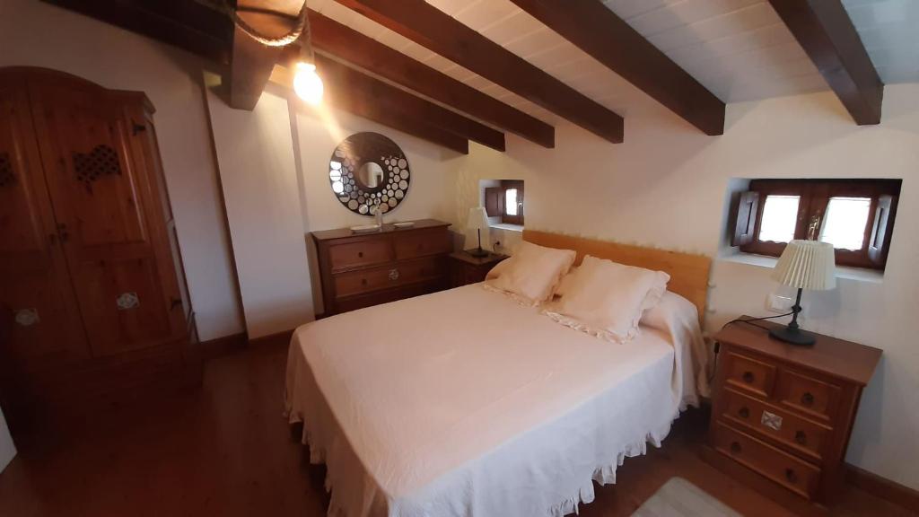 リャネスにあるEl Cantón de Poo, agradable casa adosada a 800m de la playa VV-2256-ASの白いベッドと鏡のある寝室
