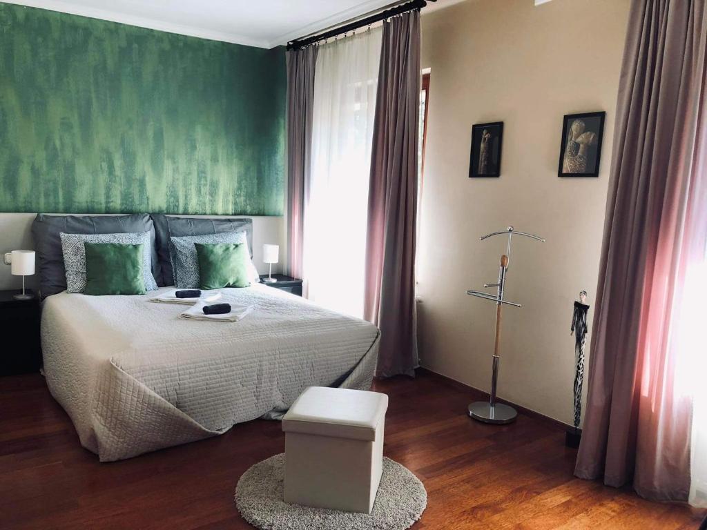 a bedroom with a bed and a green wall at Atrium Panzio in Esztergom