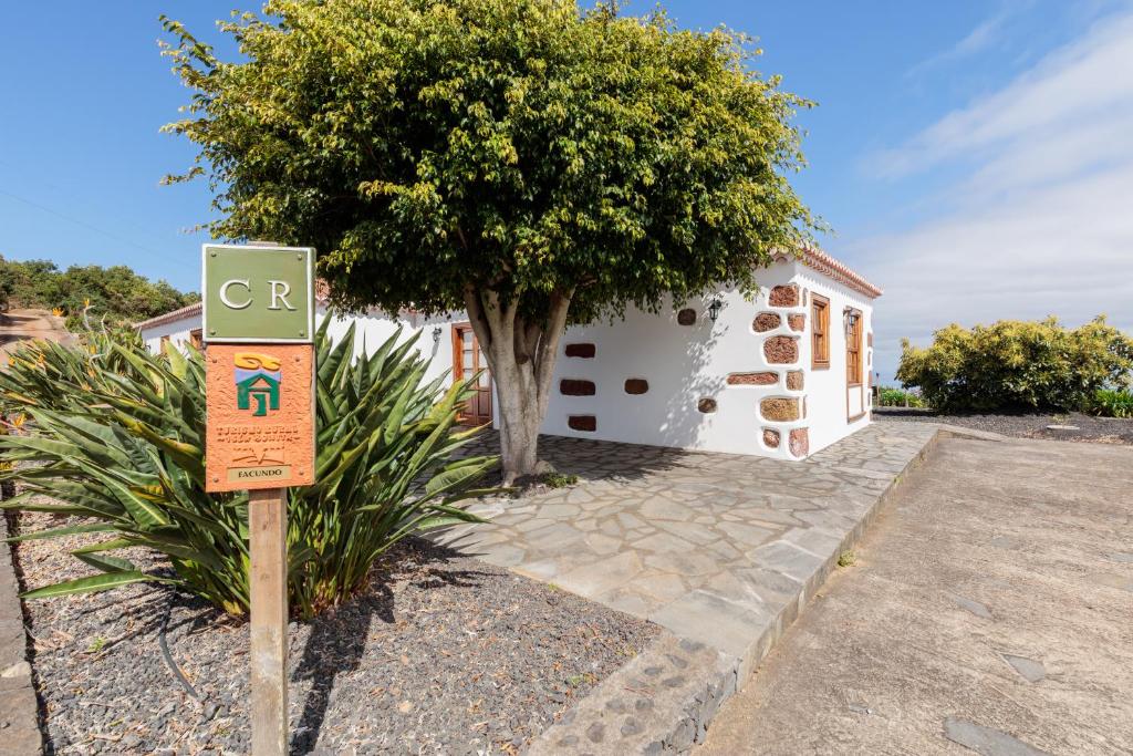 um sinal em frente a uma casa com uma árvore em Facundo A em Barlovento