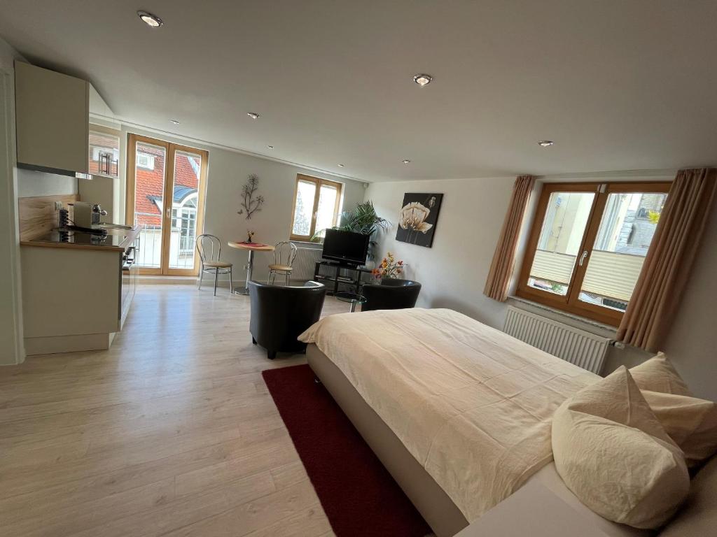 Apartment am Schloss في زيغمارينغن: غرفة نوم بسرير كبير ومطبخ
