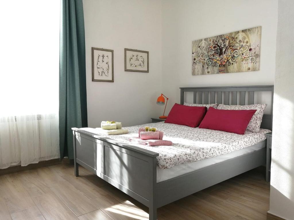 een slaapkamer met een bed met rode kussens erop bij Casa Sansevera Lucca in Lucca