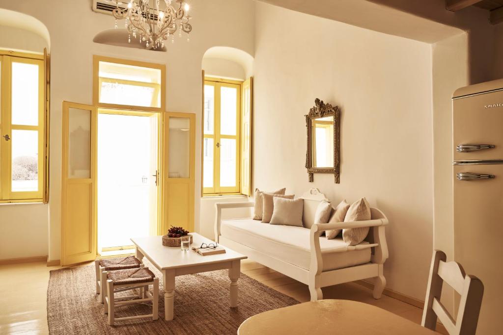 een woonkamer met een witte bank en een tafel bij Town Mansion by Monocle in Mykonos-stad