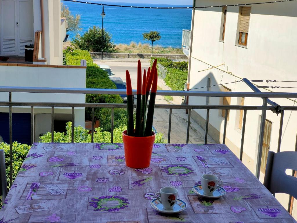 una mesa con 2 tazas de café en el balcón en A Levante, en Ascea