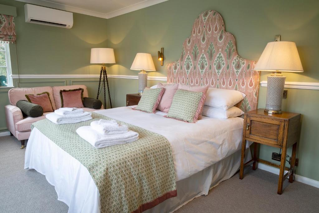a bedroom with a large bed with a large headboard at Worlington Hall in Worlington