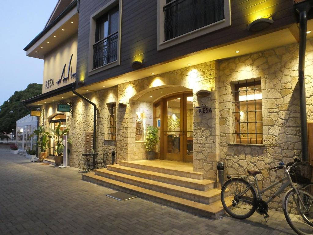 Resa Hotel Göcek في غوجيك: مبنى به سلالم خارجه مع دراجة متوقفة في الأمام