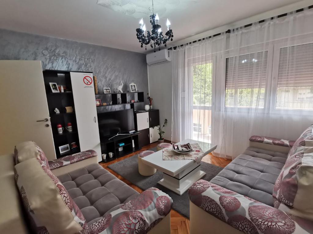 ein Wohnzimmer mit 2 Sofas und einem Tisch in der Unterkunft Apartman Caroline in Čačak