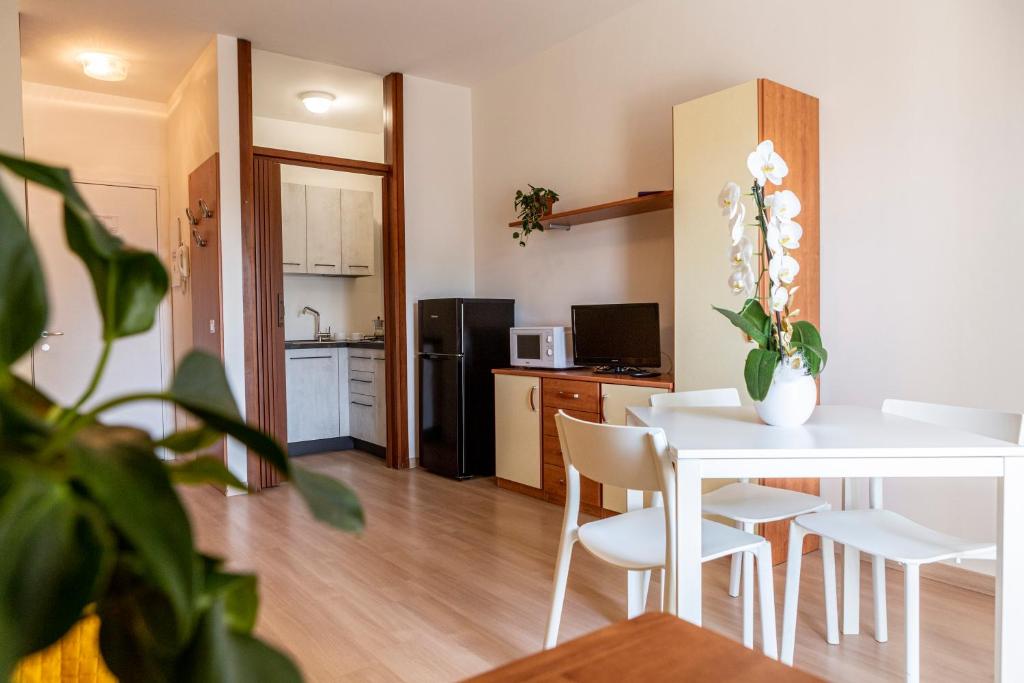 a kitchen and dining room with a white table and chairs at Holiday Appartamenti in Grado