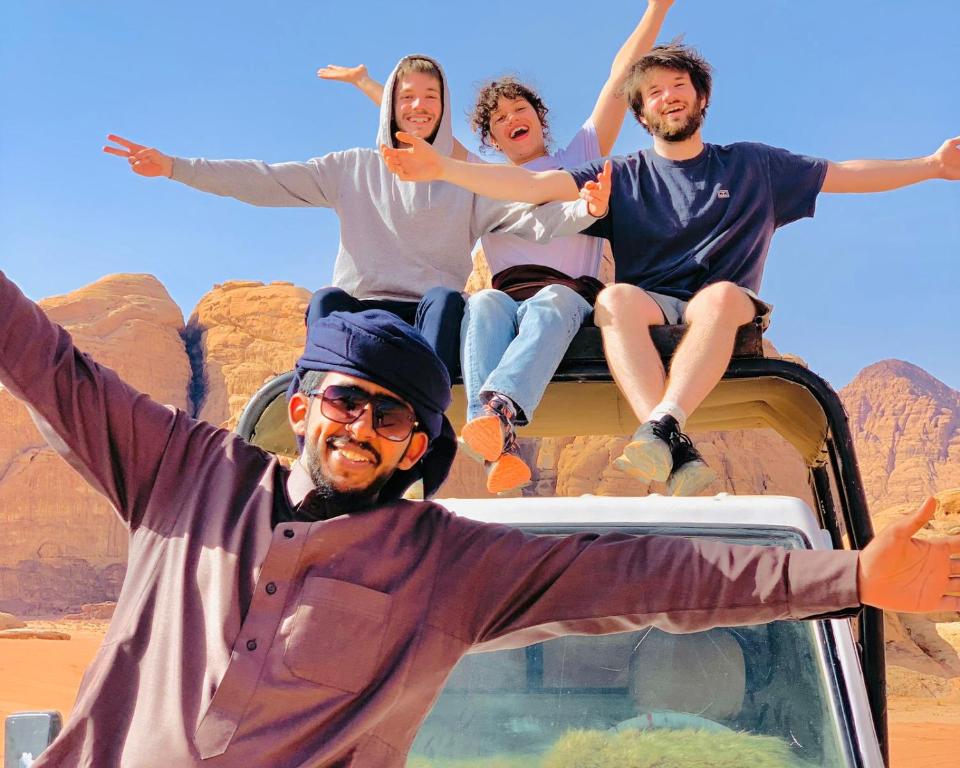un grupo de personas sentadas en el techo de una camioneta en Wadi Rum Local Guide, en Wadi Rum