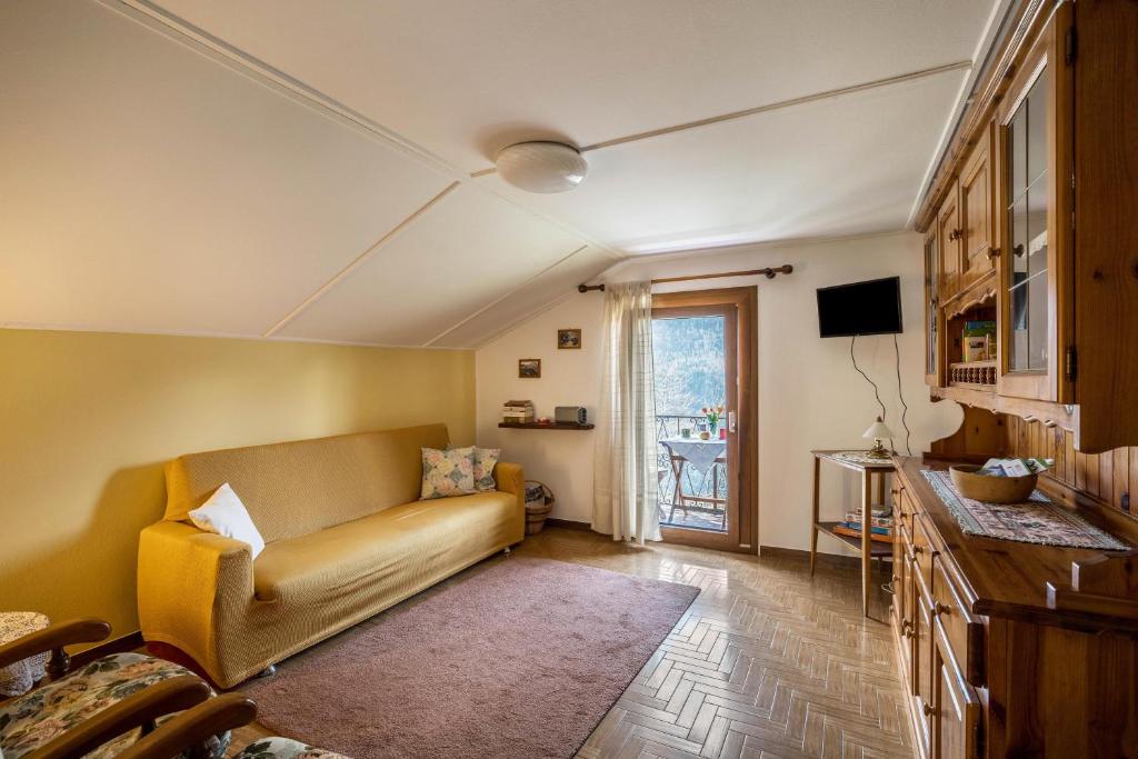 salon z kanapą i oknem w obiekcie La Mansarda di Chiara e Silvio w mieście Trasquera