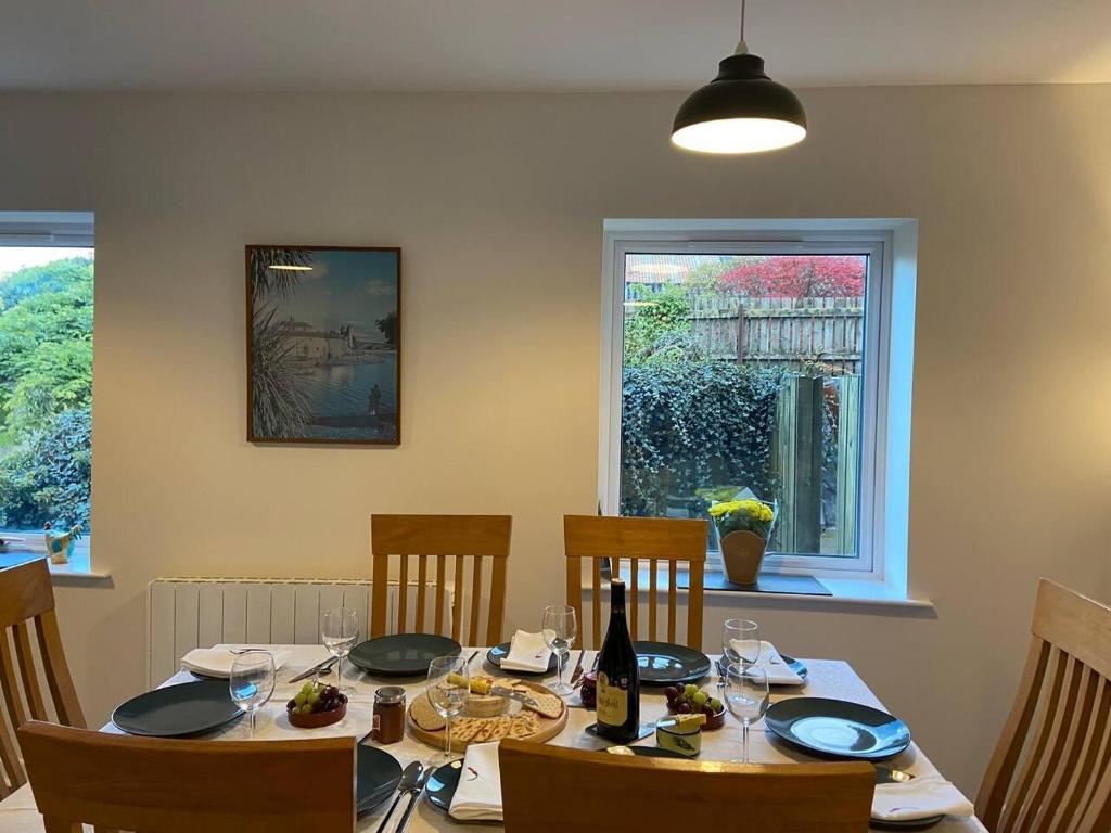 einen Esstisch mit Stühlen und eine Flasche Wein in der Unterkunft Town house in ideal location central Enniskillen in Enniskillen