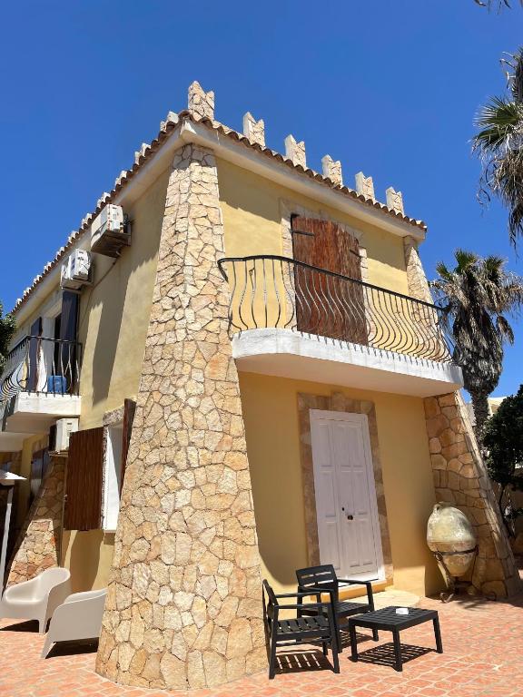 a building with a balcony and a table in front of it at Villa Sofia in Lampedusa