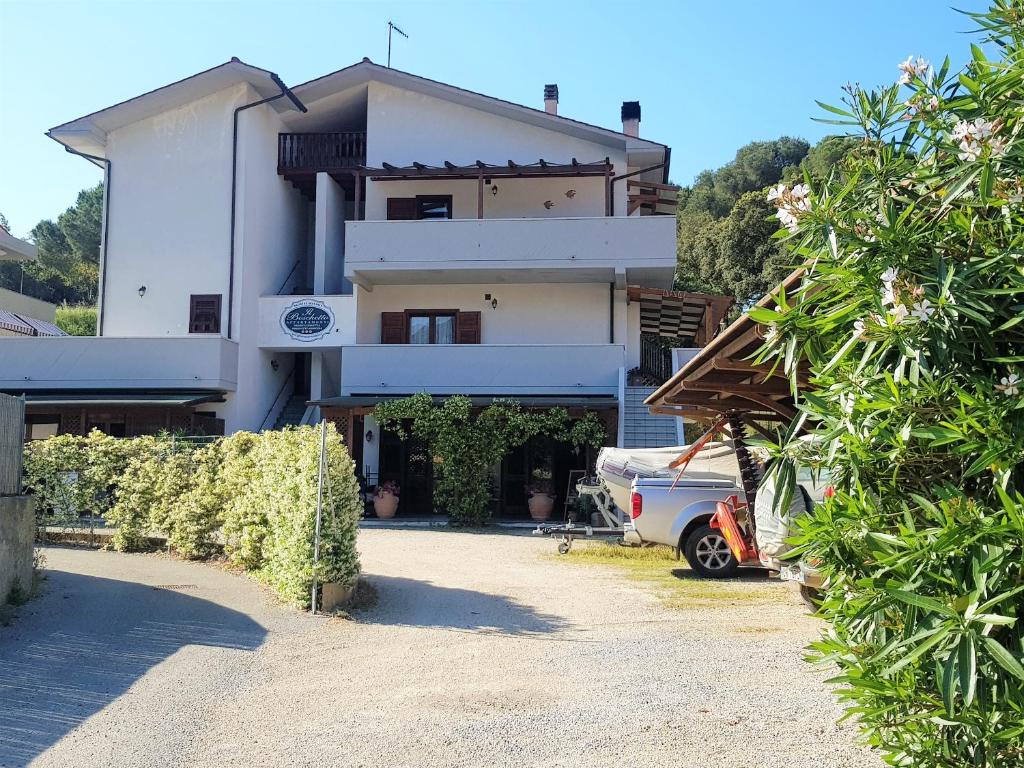 a house with a car parked in front of it at Il Boschetto in Porto Azzurro