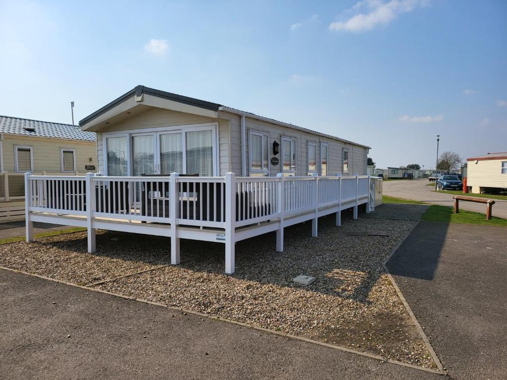 a small house with a white porch and a porch at 2BR-Sleeps6-Fireplace-Parking-Patio-Seaside in Clacton-on-Sea