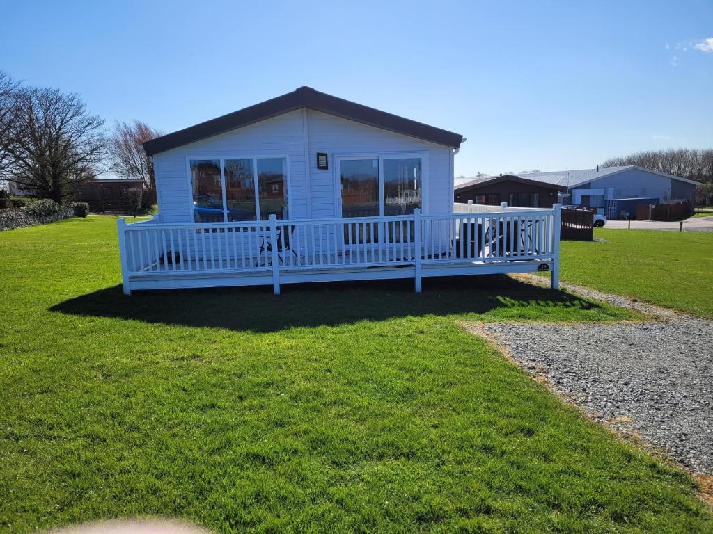 a small white house with a porch on the grass at Remarkable 3-Bed House in Hull in Hull