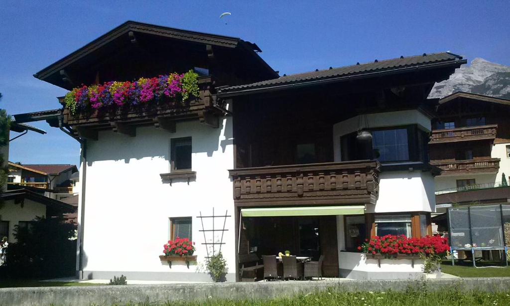 un bâtiment blanc avec des fleurs sur un balcon dans l'établissement Ferienwohnung Gleirscher, à Neustift im Stubaital