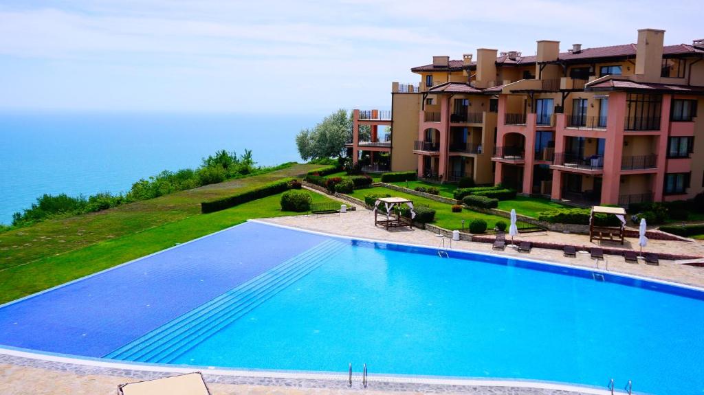 une grande piscine en face d'un grand bâtiment dans l'établissement Ваканционни Апартаменти Калиакрия - Holiday Apartments Kaliakria, à Topola