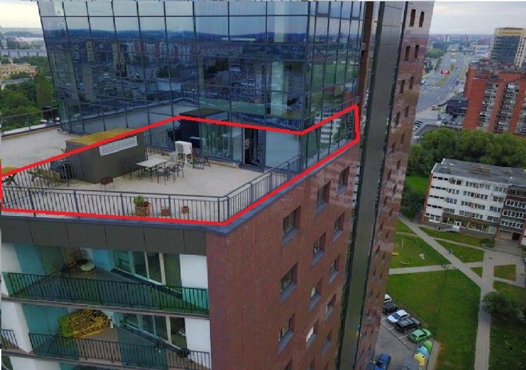 een hoog gebouw met een balkon erboven bij Sunset Terrace Apartment in Klaipėda