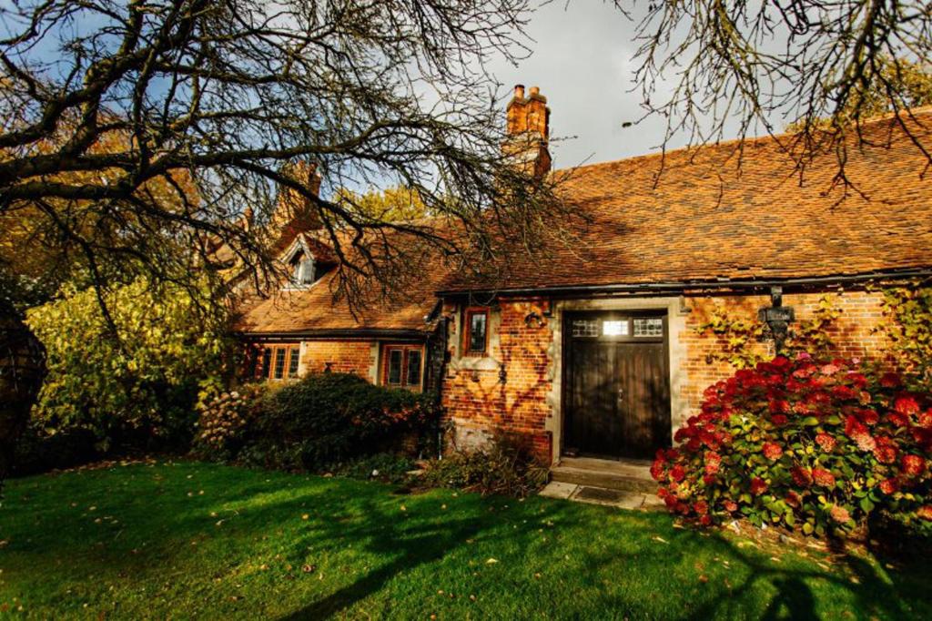 a brick house with a door in a yard at Elizabethan Manor House - Sleeps 2-4 - Parking in Burnham-on-Crouch