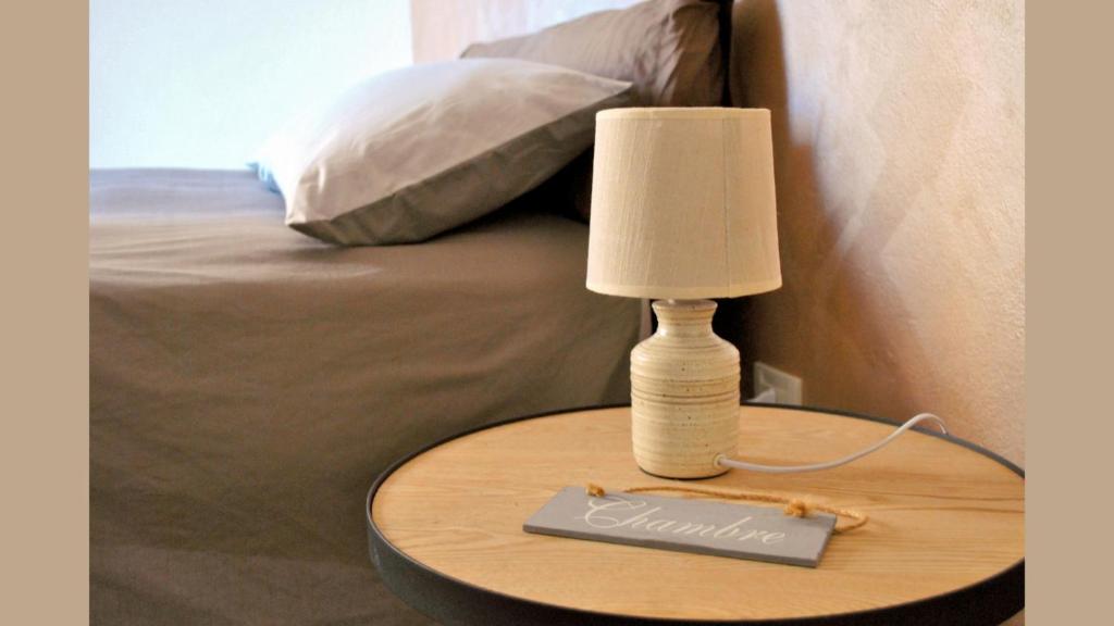 een lamp op een tafel naast een bed bij Mysa Properties - Casa vacanze Arnasco in Arnasco