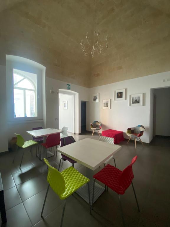 ein Zimmer mit Tischen und Stühlen und einem Fenster in der Unterkunft Nova Domus in Castellaneta