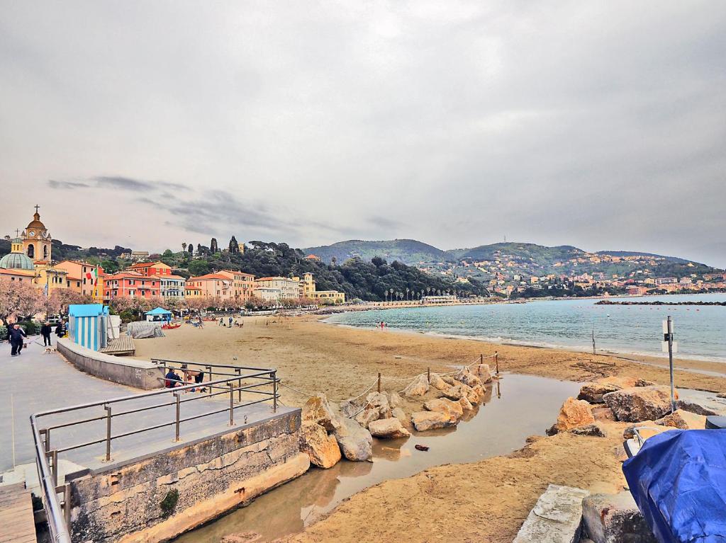 a beach with people walking on the sand and the water at A Sante in Lerici