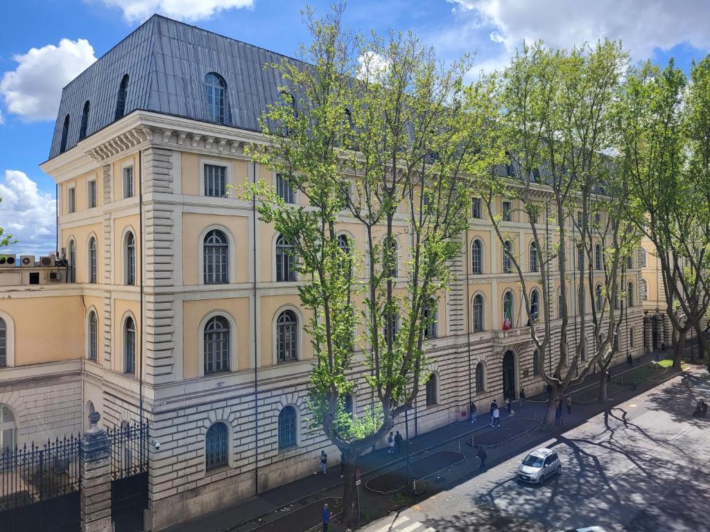 un grand bâtiment avec des arbres devant dans l'établissement Beatrix House, à Rome