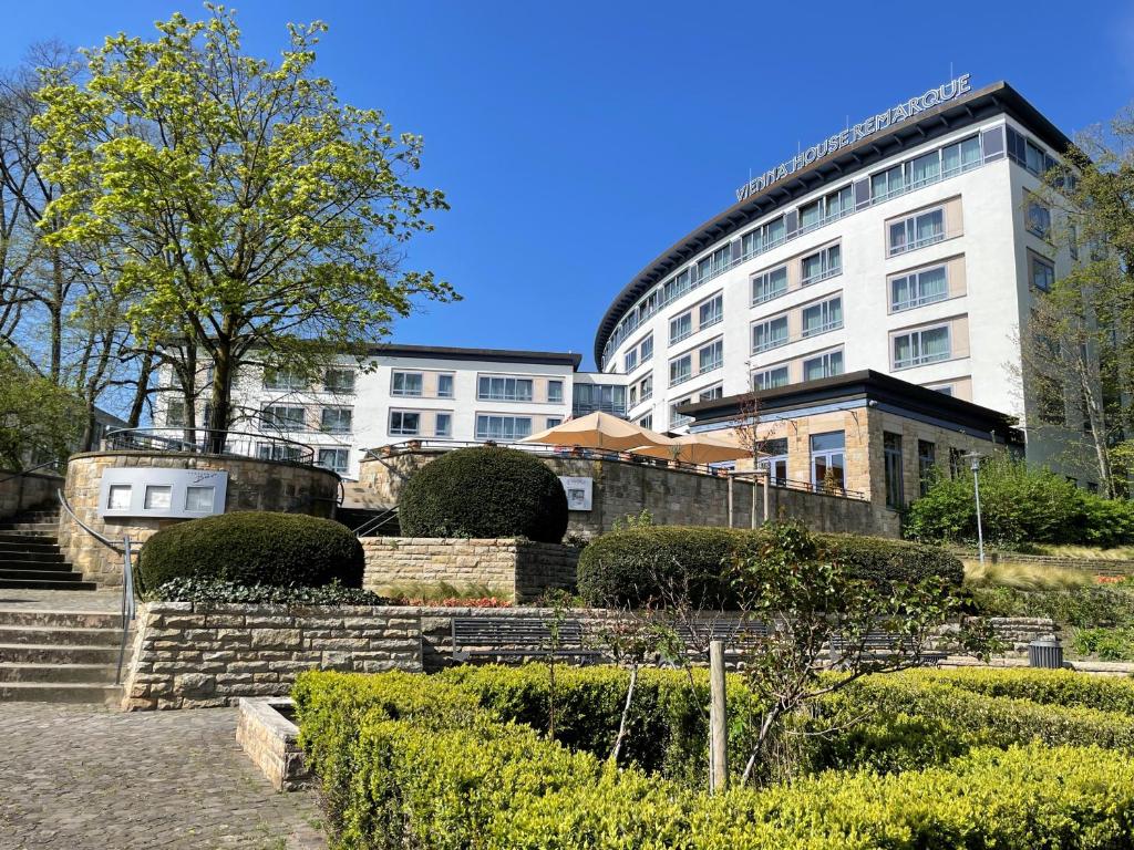 a large white building with a staircase in front of a building at Vienna House by Wyndham Remarque Osnabrück in Osnabrück