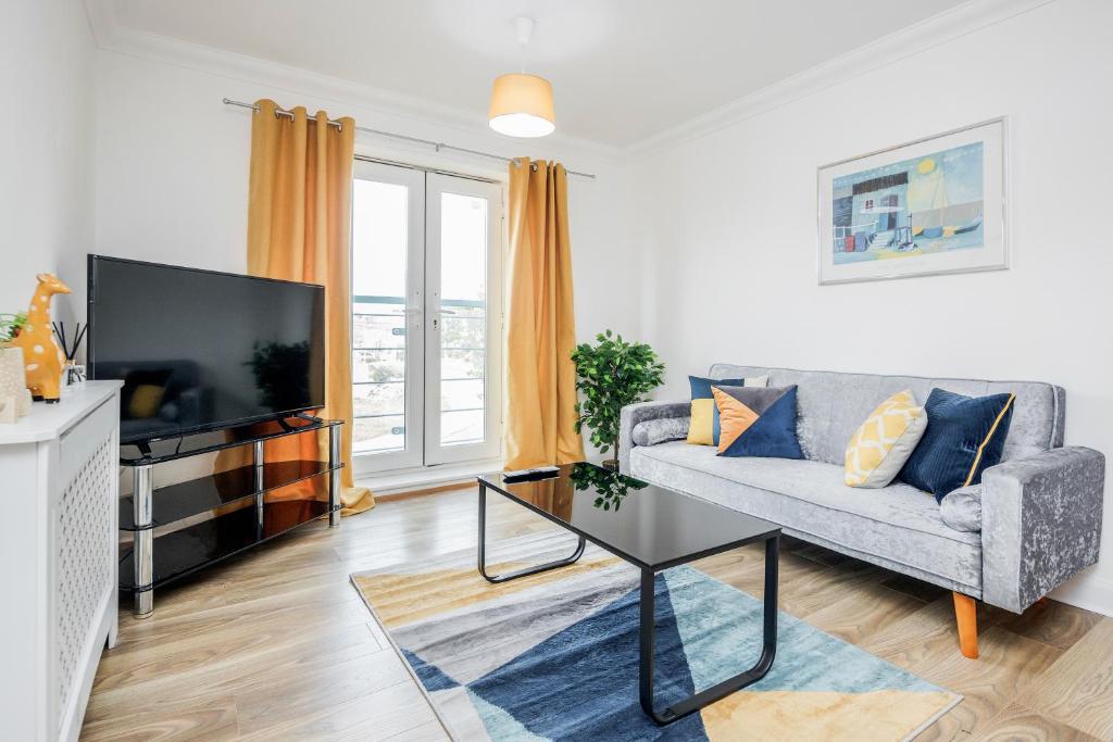 a living room with a couch and a tv at Bright and cozy 2-Bed Apartment in Dagenham in Dagenham