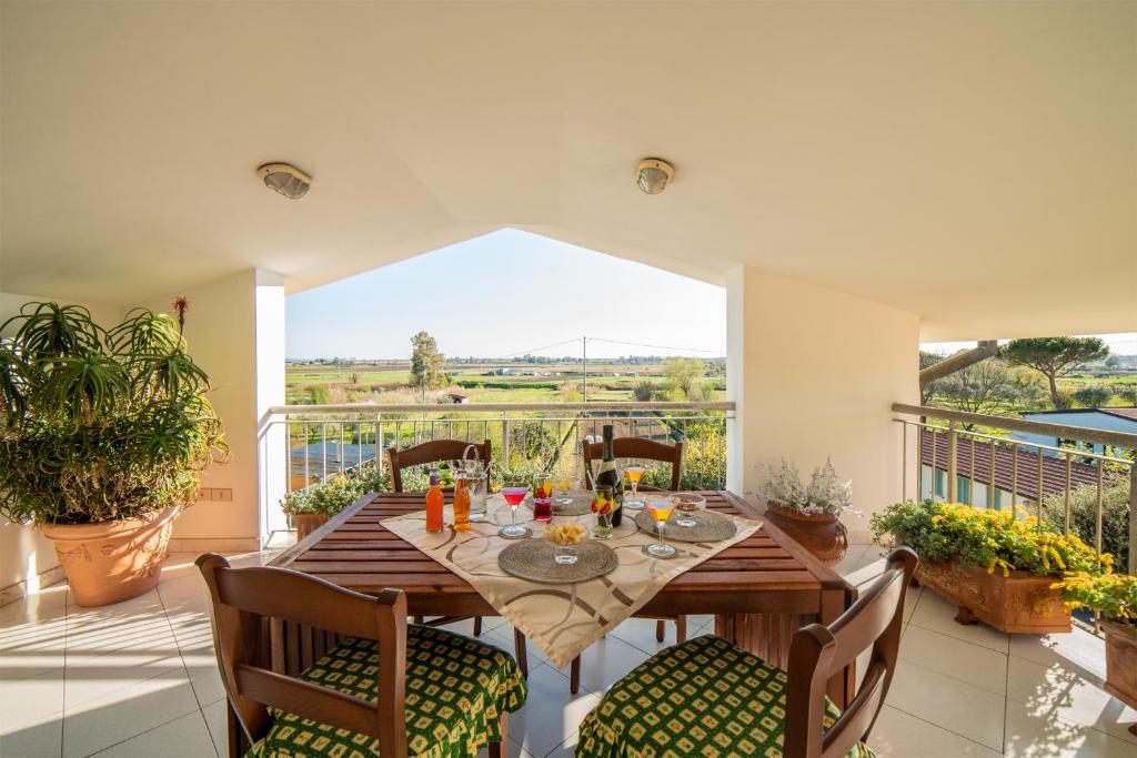 ein Esszimmer mit einem Tisch und Stühlen auf dem Balkon in der Unterkunft EUCALIPTO, splendido con terrazza panoramica sulla campagna versiliese in Massarosa