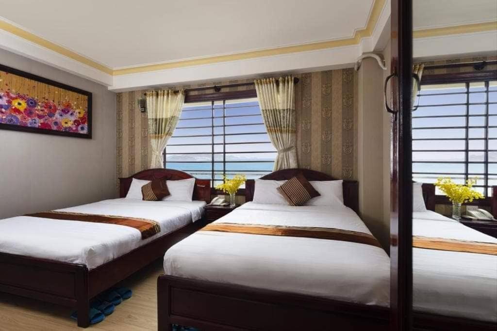 2 Betten in einem Zimmer mit Fenstern in der Unterkunft VINH MINH HOTEL in Nha Trang