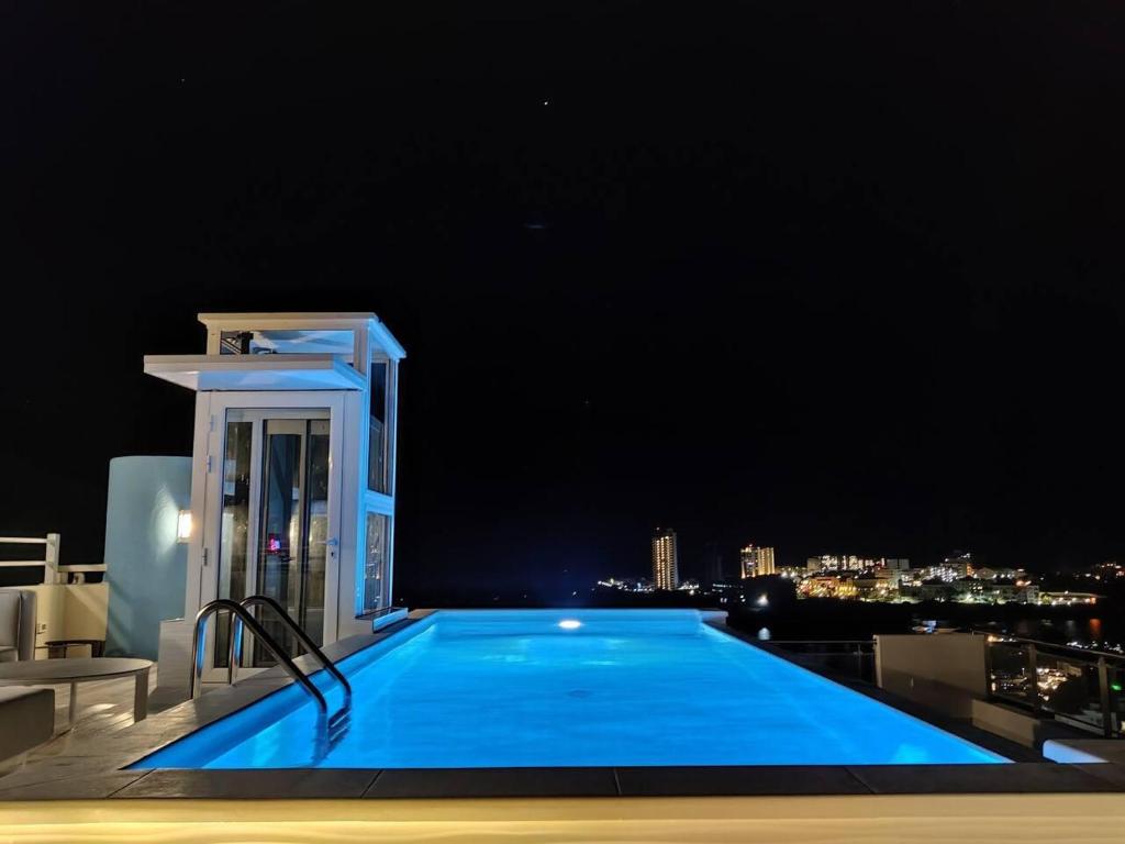 a large blue swimming pool on top of a building at Serenity Penthouse - The Pinnacle of Luxury in Maho Reef