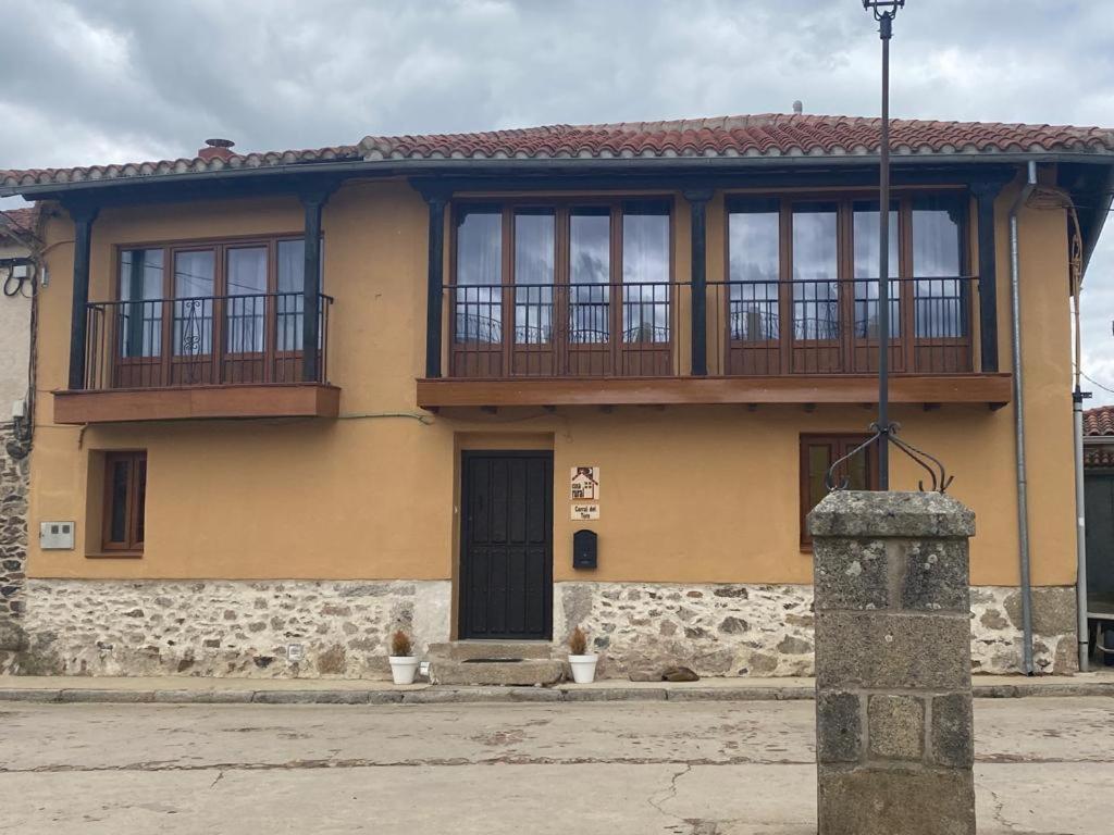 Una casa amarilla con balcón en la parte superior. en casa rural corral del Toro, 