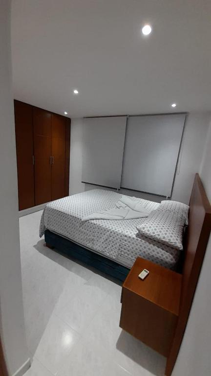 1 dormitorio con cama y mesa de madera en Aparta suit Rodadero, en Gaira
