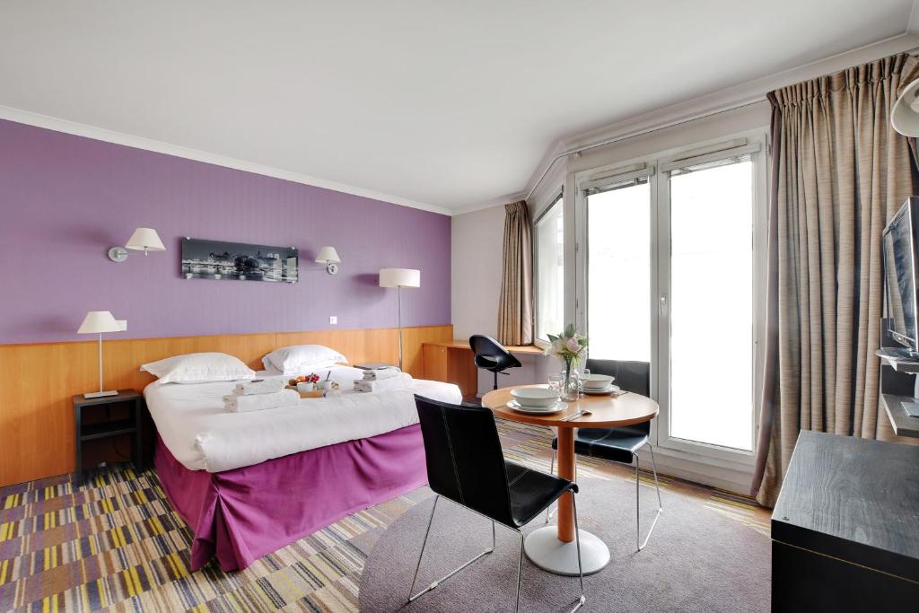 Habitación de hotel con cama y mesa en CMG - Cosy & charmant appartement Paris en Issy-les-Moulineaux