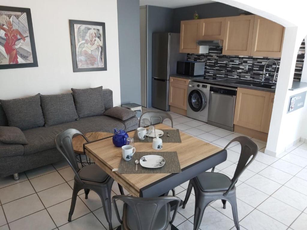 Il dispose d'une cuisine et d'un salon avec une table et des chaises en bois. dans l'établissement Villa Village Naturiste Farel, au Cap d'Agde