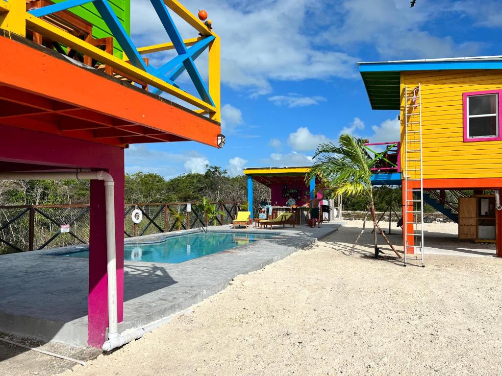 West End Cabanas في سان بيدرو: مسبح في ملعب مع مباني ملونة