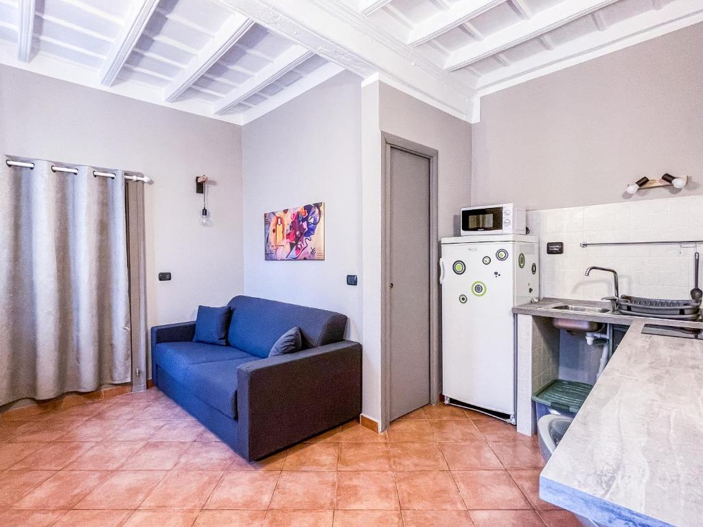 sala de estar con sofá azul y nevera en MYHOUSE INN LE ROSINE - Affitti Brevi Italia, en Turín