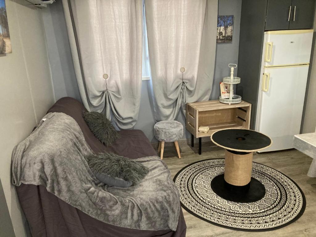 Zimmer mit einem Bett, einem Tisch und einem Fenster in der Unterkunft Mobilhome TOUT CONFORT in Mimizan