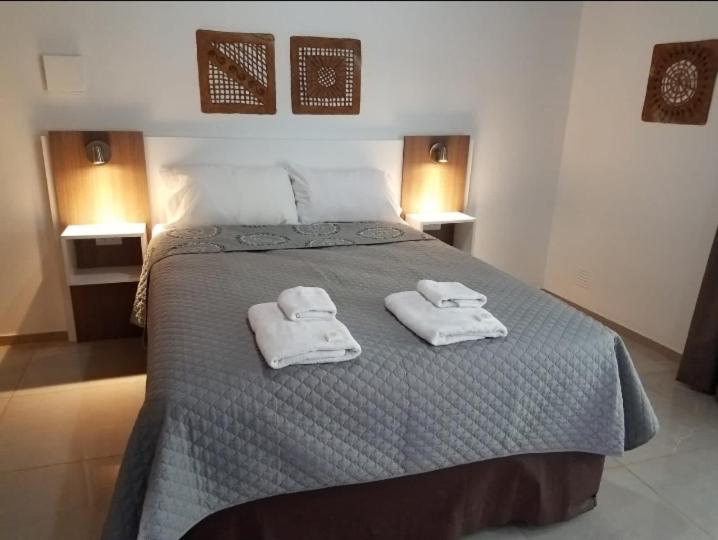 una camera da letto con un grande letto con asciugamani di Departamentos Mendoza a Mendoza