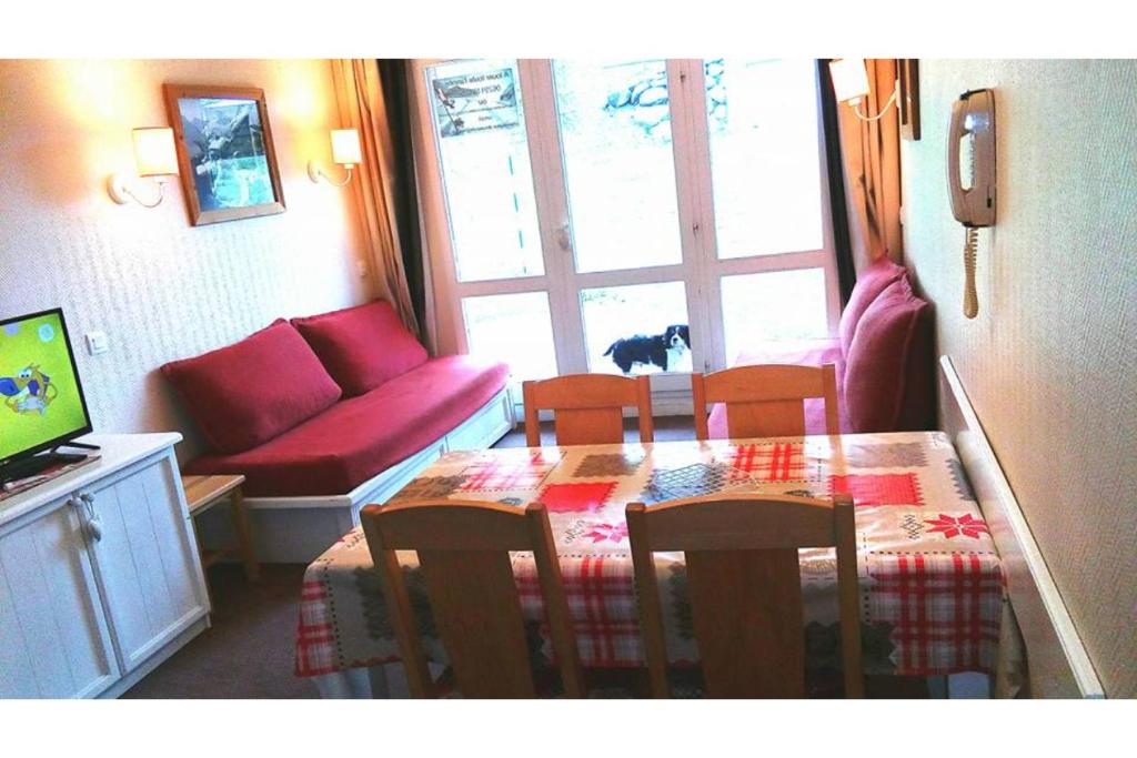 sala de estar con mesa, sillas y sofá en Appartement aux pieds des pistes, en Valmeinier