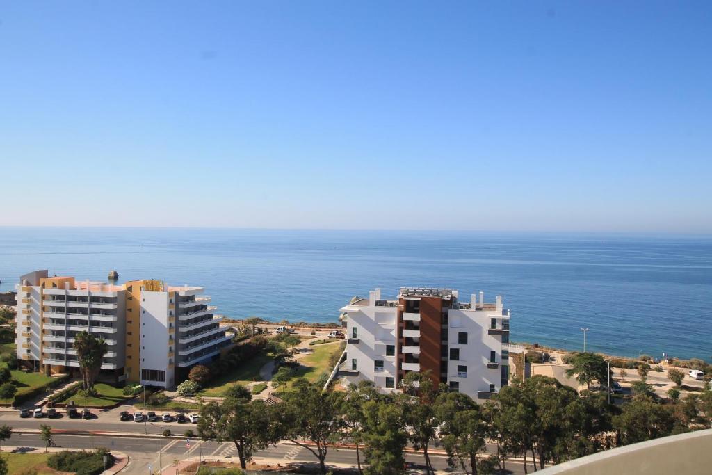 - une vue sur deux bâtiments et l'océan dans l'établissement Praia_da_Rocha_Vista_Mar/Ocean_View, à Portimão