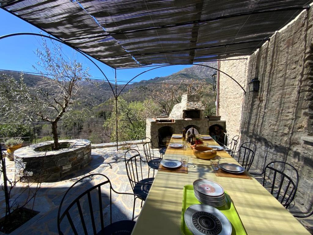 una mesa y sillas en un patio con vistas en Superbe maison dans village au coeur de la Corse A casa Suttana, en Verdese