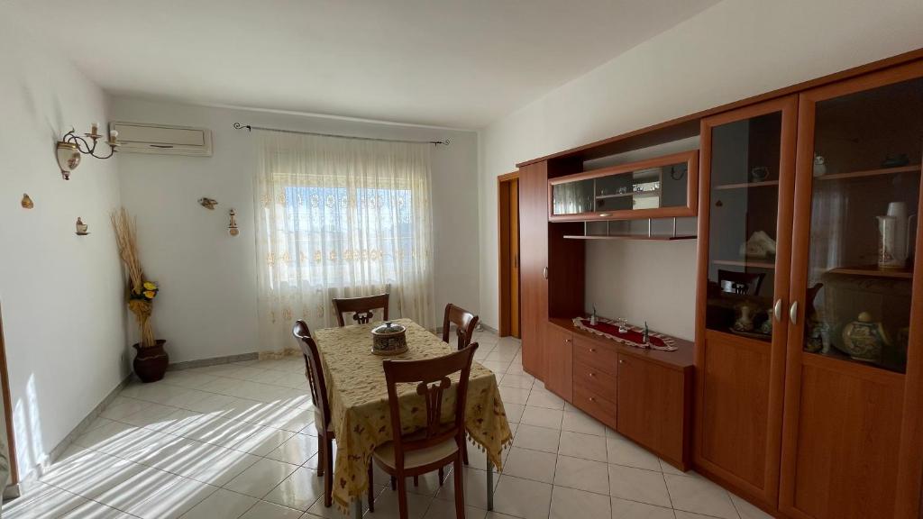 uma cozinha e sala de jantar com mesa e cadeiras em Appartamento Canalotto 65 2 piano em Realmonte